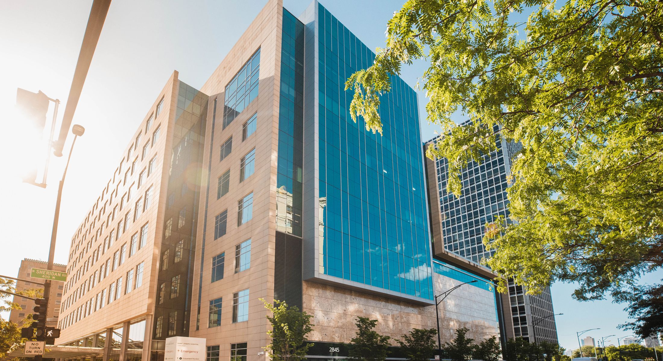 Modern buildings with glass facades and trees.